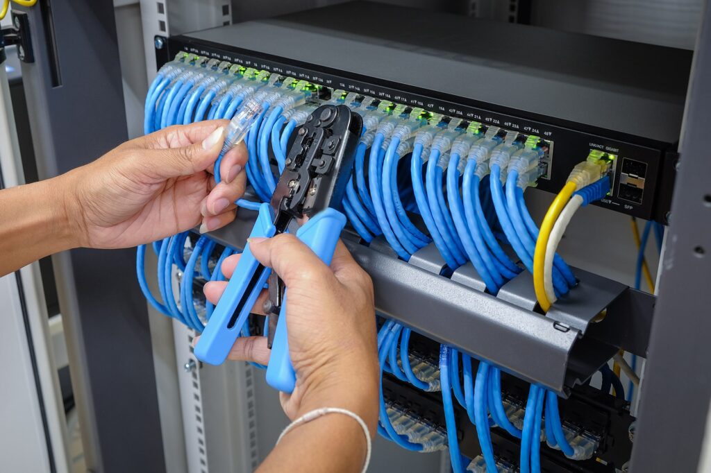 Hand,Of,System,Administrator,With,Network,Cable,Connected,To,Patch Structured-Cabling
